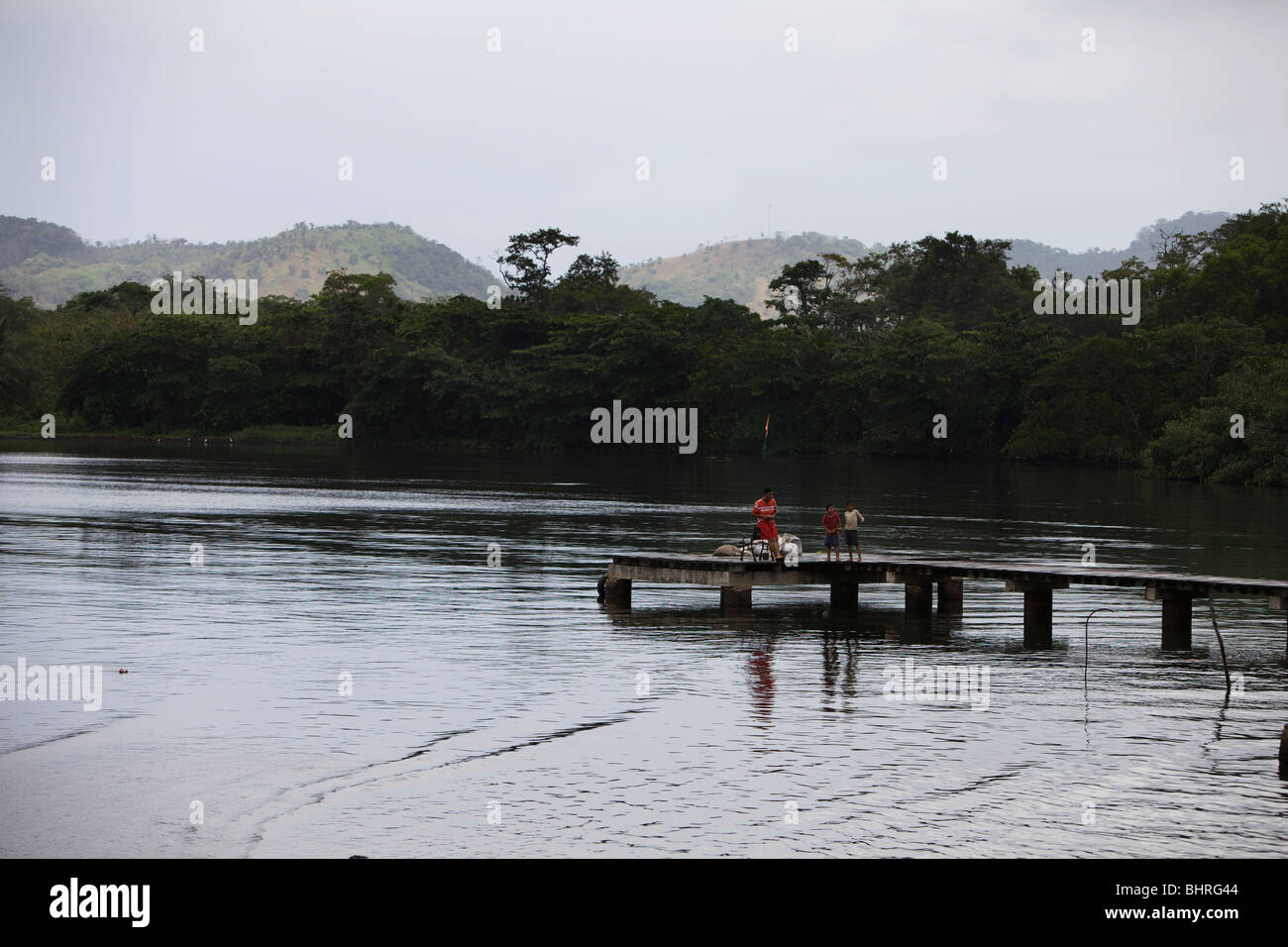 Father and 2 sons fishing from a pier in Portobelo, Panama, longshot Stock Photo