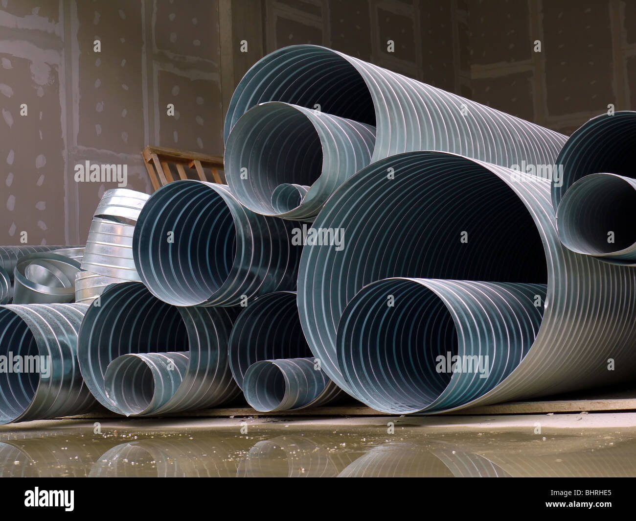 Pile of steel corrugated pipes stacked at construction site Stock Photo