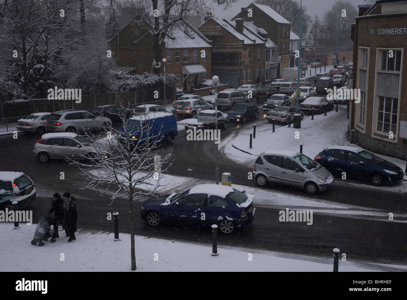 The school run in Heston village centre on a snowy day in winter, West