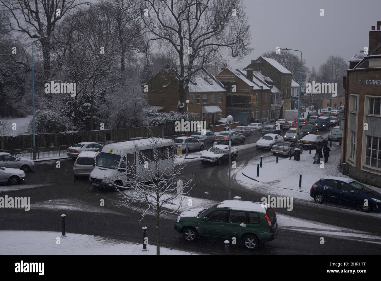The school run in Heston village centre on a snowy day in winter, West
