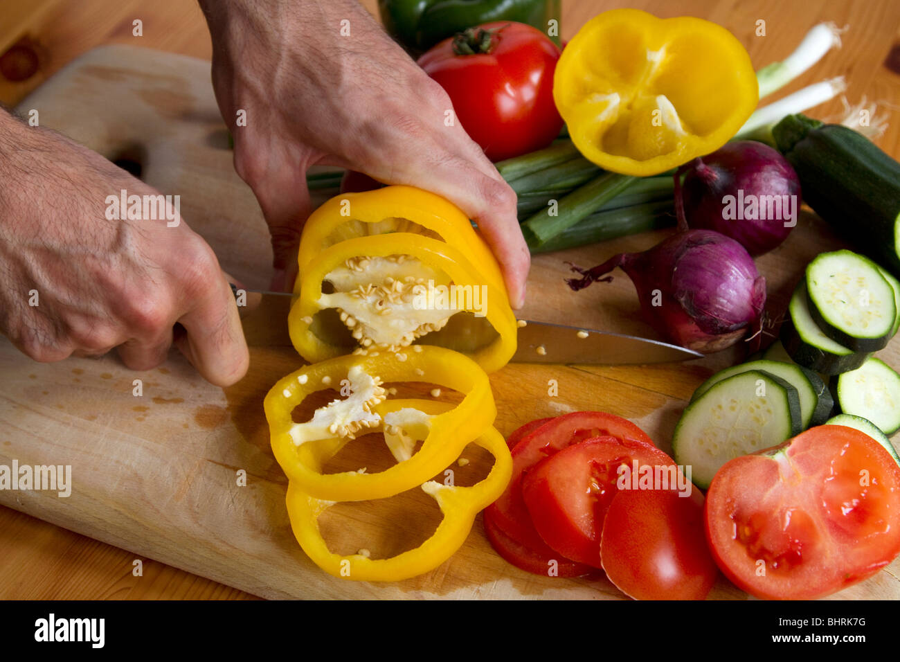 Close up of man's hands cutting yellow pepper Stock Photo