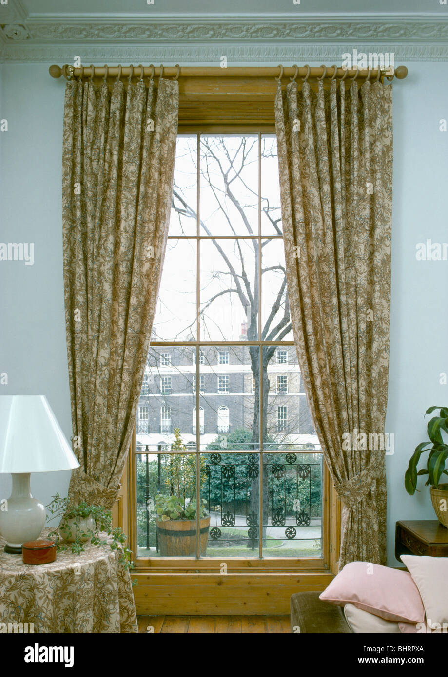 Patterned curtains at sash window with view of the street in townhouse