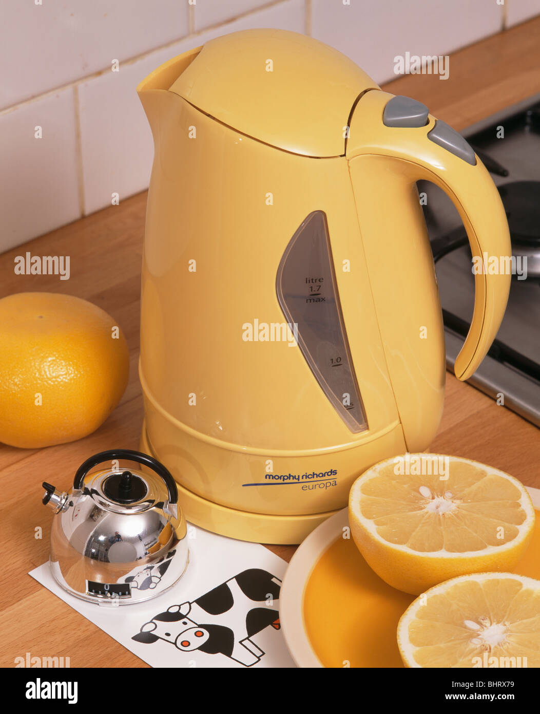 https://c8.alamy.com/comp/BHRX79/close-up-of-bright-yellow-plastic-kettle-and-small-kettle-shaped-chrome-BHRX79.jpg