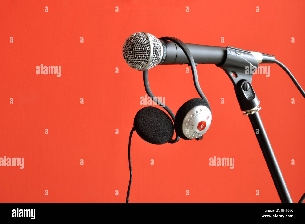 Microphone on stand with headphones with a red background Stock Photo