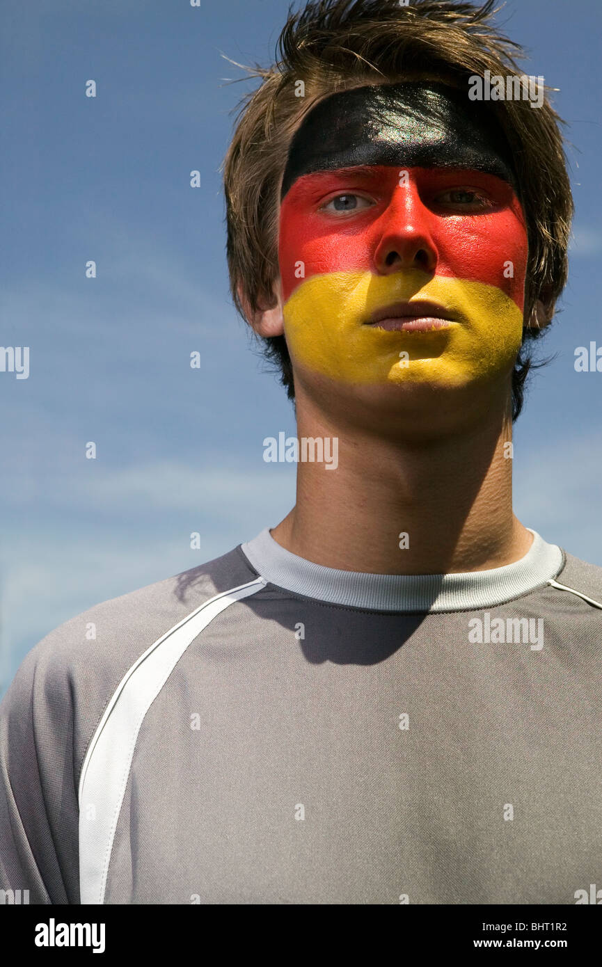 a serious looking German football supporter with the German's flag painted on his face Stock Photo