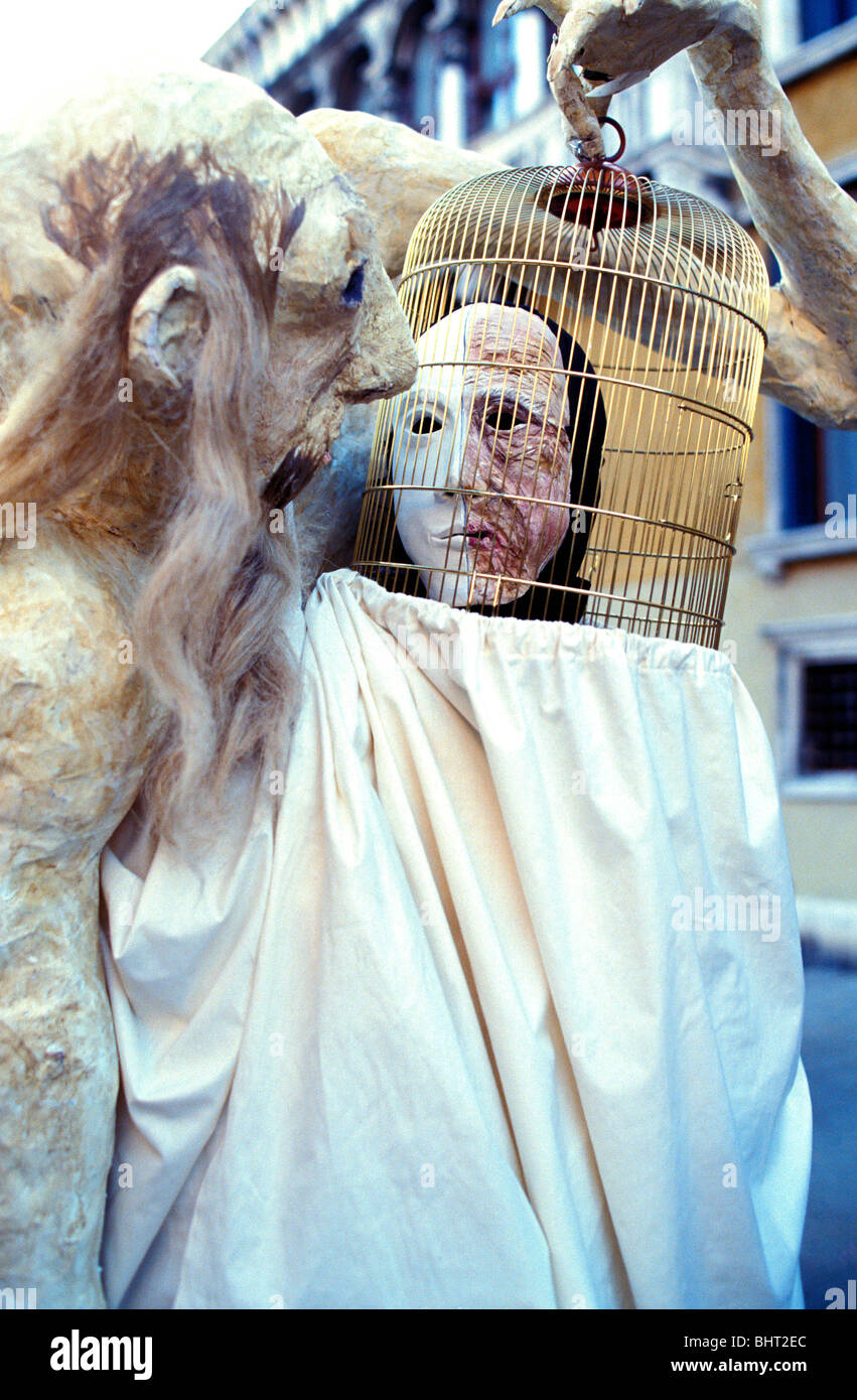 Person wearing paper mache head mask simulating an old man and holding
