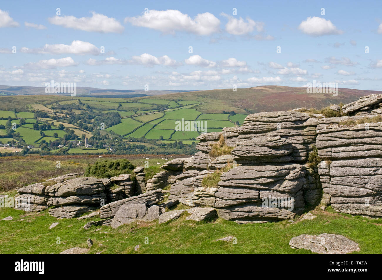 Pil Tor on Dartmoor, with Widecombe-in-the-Moor down in the valley beyond Stock Photo