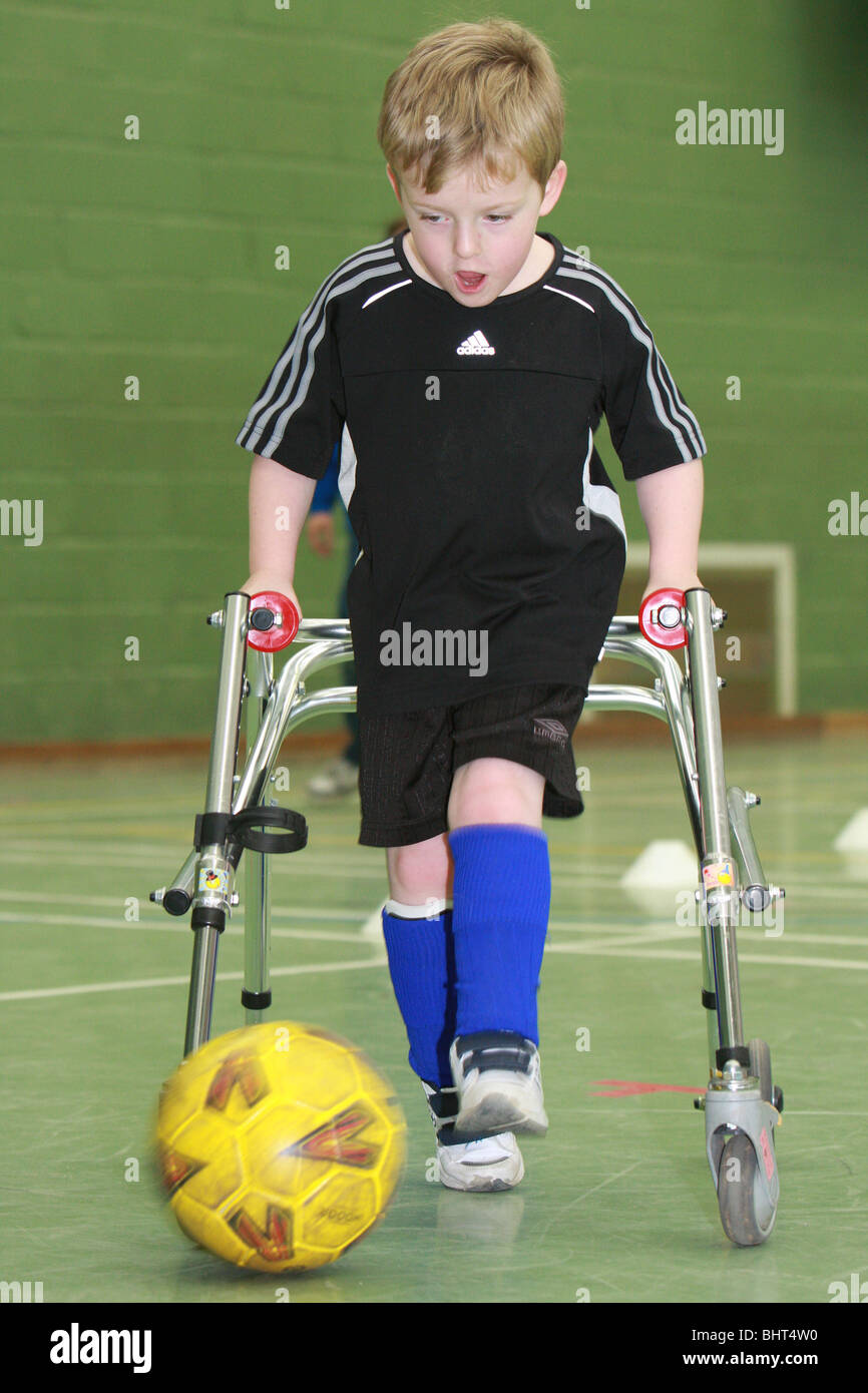 A young disabled boy playing football Stock Photo