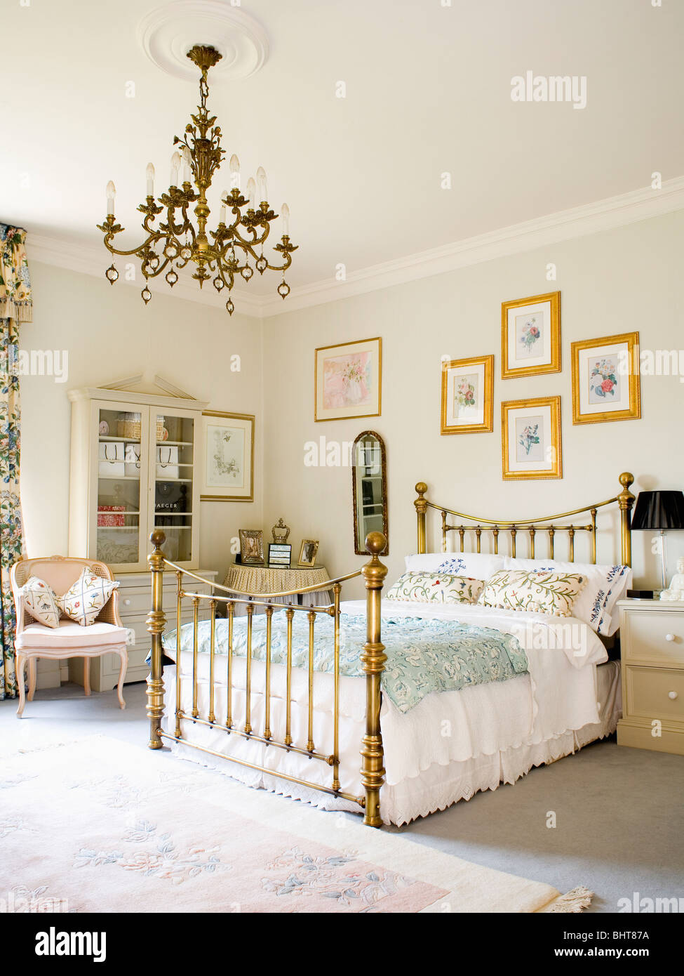 Brass chandelier and antique brass bed in traditional bedroom