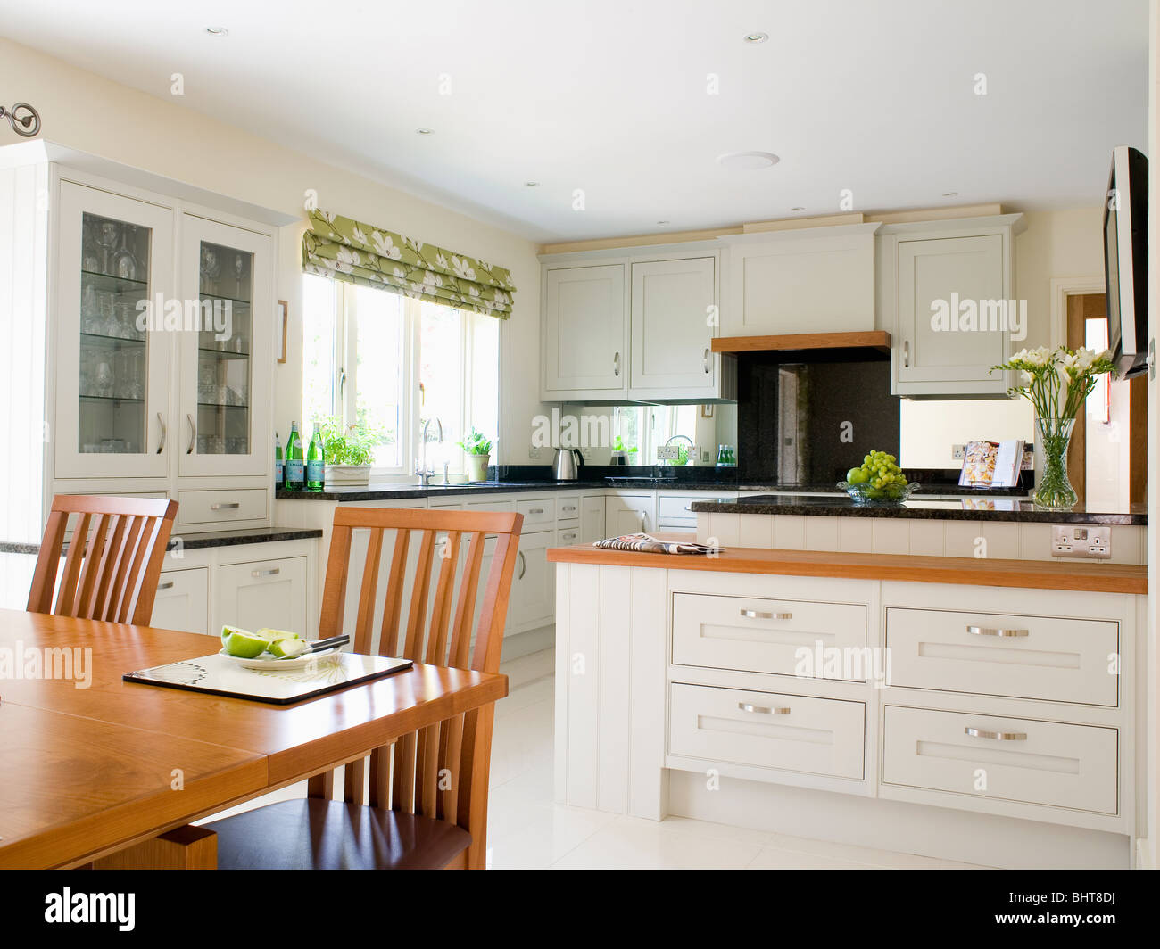 Large modern white kitchen dining room with simple wood table and ...