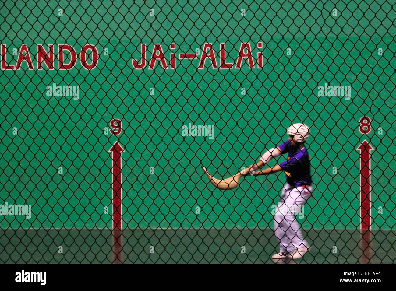 Jai alai player prepares to throw the ball (pelota) from his woven basket (cesta) at the Orlando fronton  in Fern Park, Florida Stock Photo