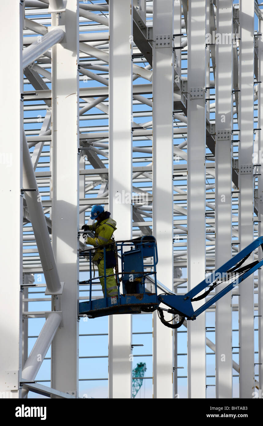 construction worker on hoist works at steel frame Stock Photo