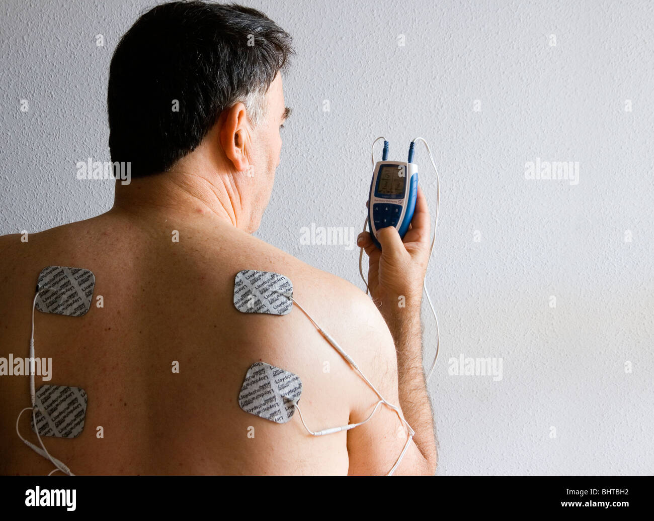 https://c8.alamy.com/comp/BHTBH2/man-using-a-dual-channel-tens-machine-for-pain-relief-BHTBH2.jpg