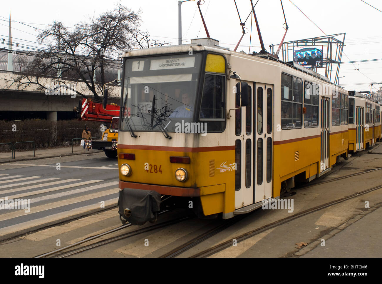 Tram passing the stadium next to a pedestrian crossing, Budapest, Hungary. Stock Photo