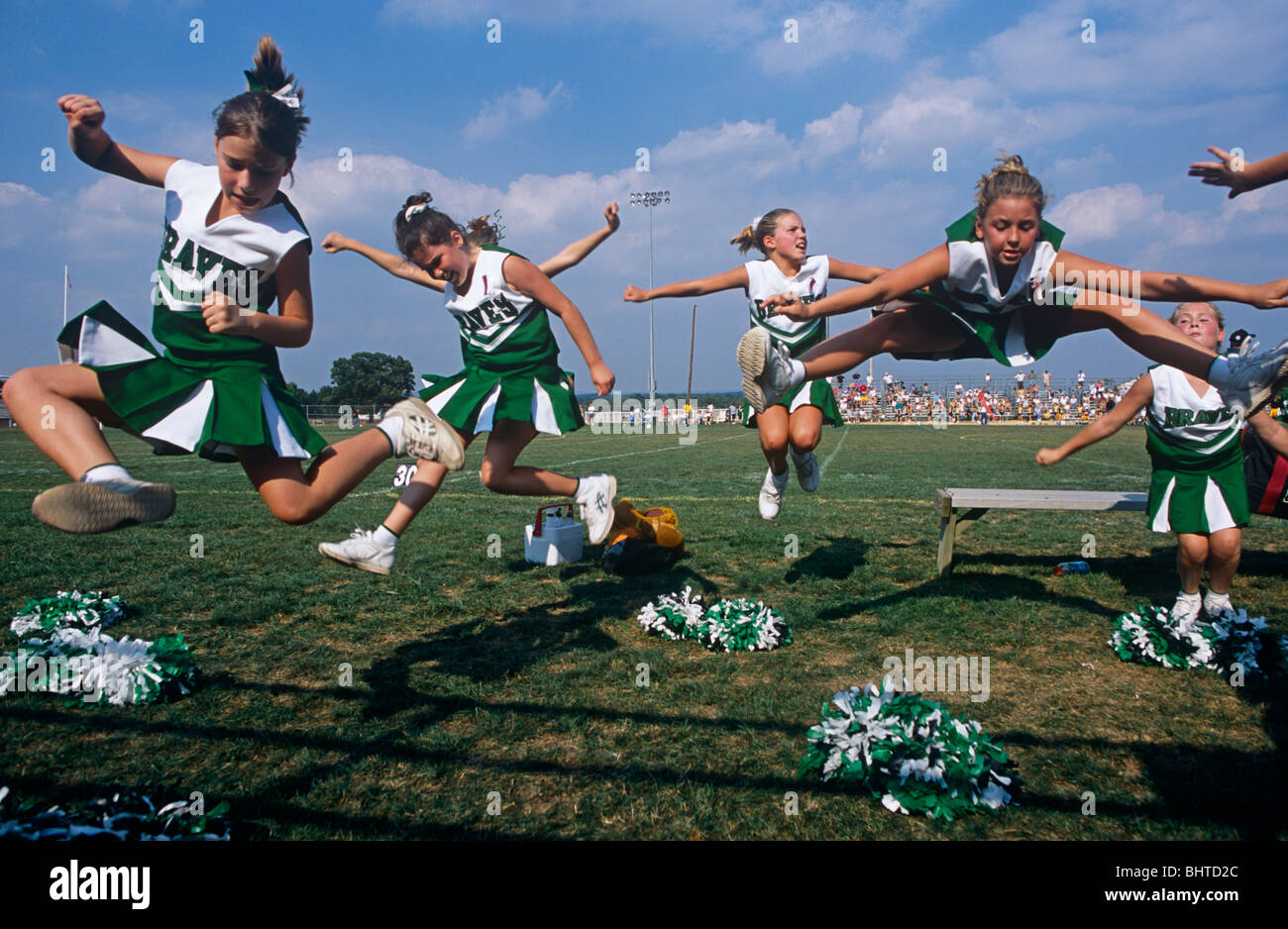 Leaping into the air all together are young members of the Donegal High School football cheerleaders squad in Pennsylvania, USA. Stock Photo