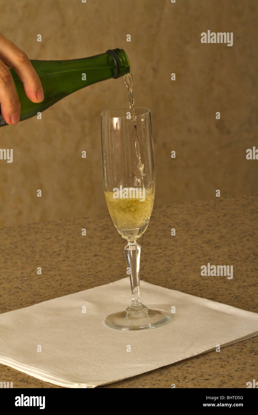 A glass of sparkling white wine poured from a half bottle Stock Photo