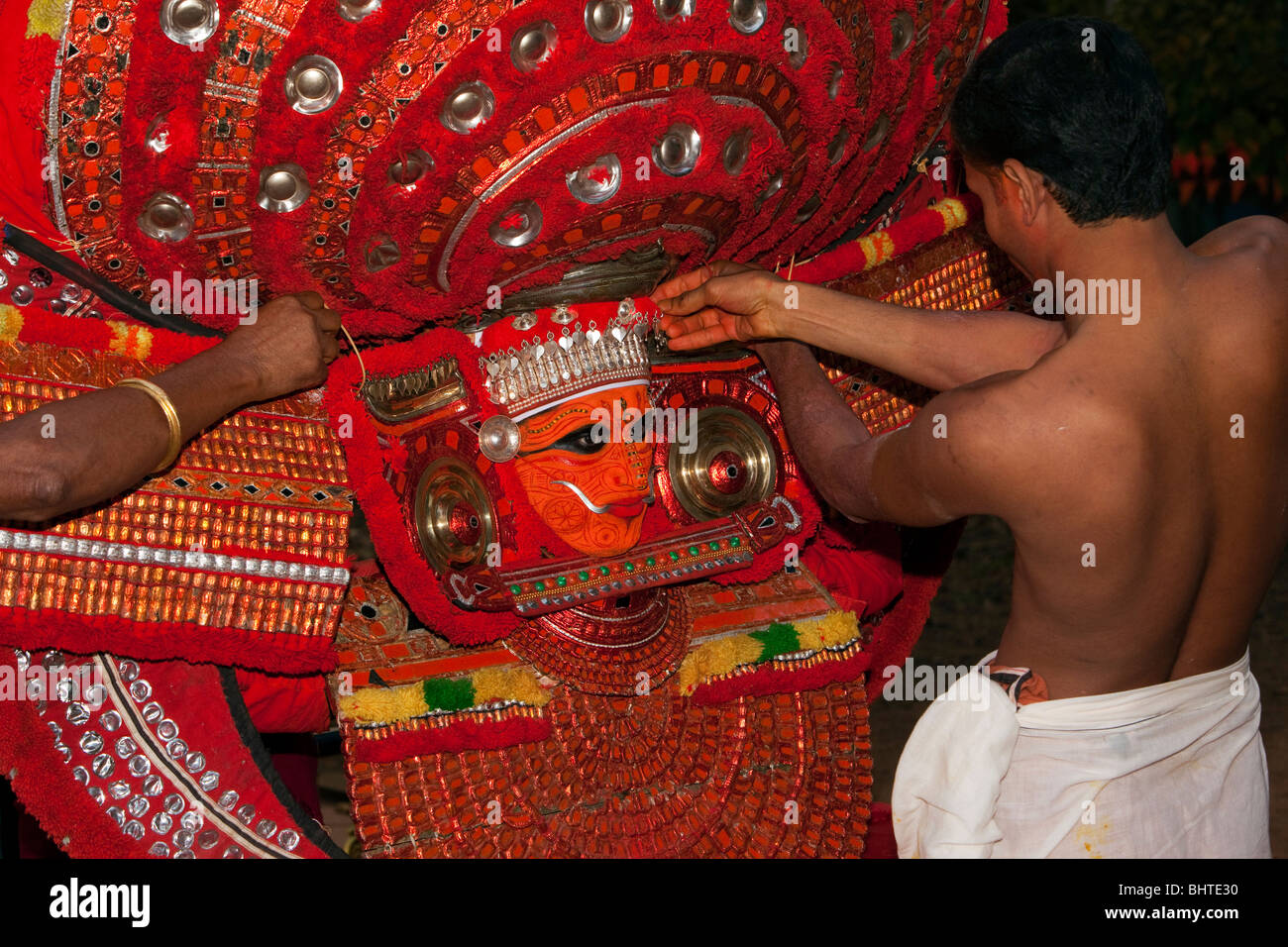 India, Kerala, Cannanore (Kannur), Theyyam ancient pre Hindu folk art ritual, supporters preparing Naga Kanni serpent deity Stock Photo