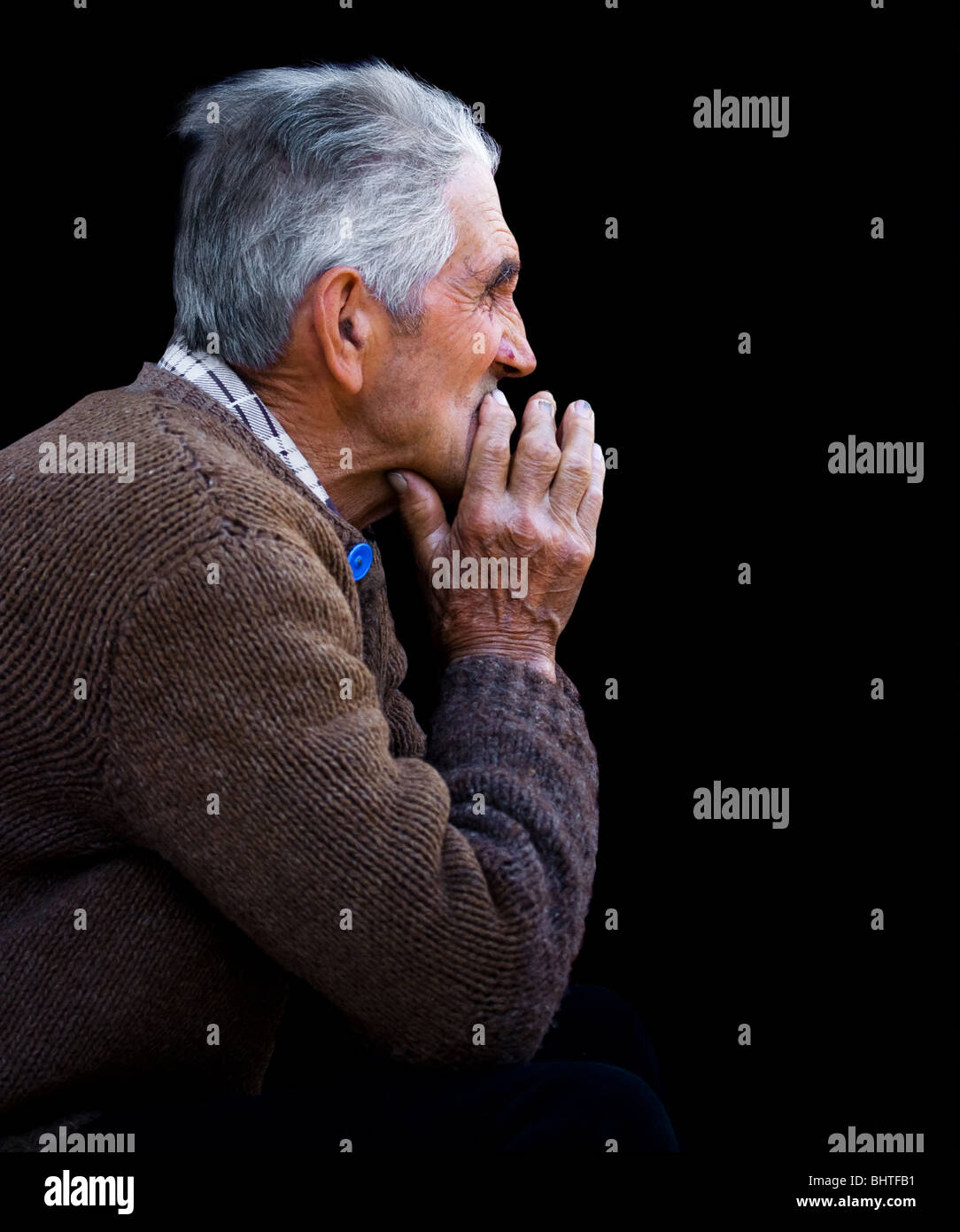 Low key portrait of an old man looking far away in a distance Stock Photo