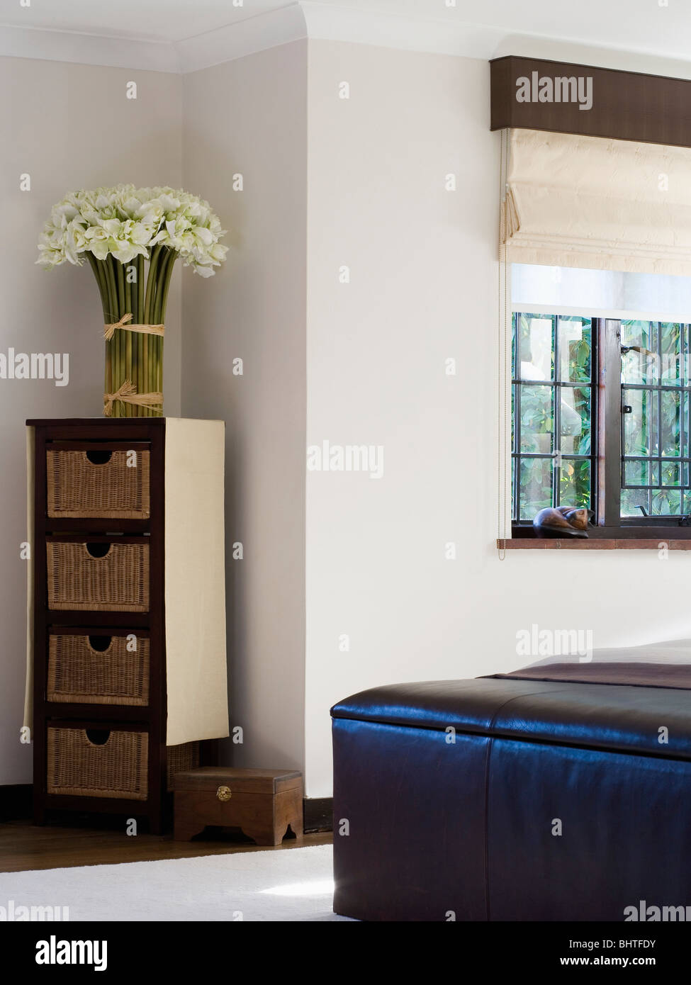 White Orchids On Narrow Chest Of Drawers In Corner Of Modern