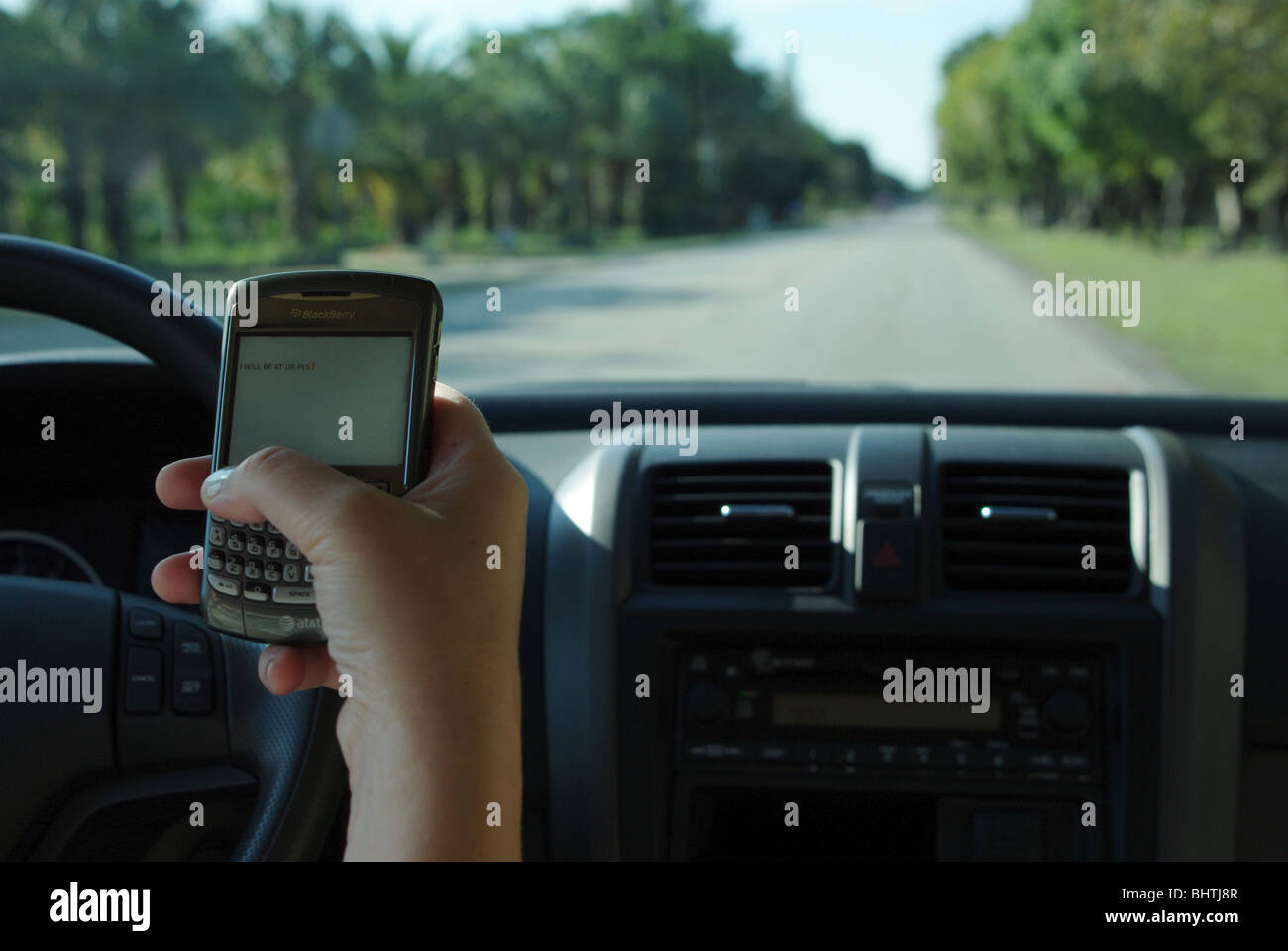 Woman is using PDA to check and type text messages while driving her