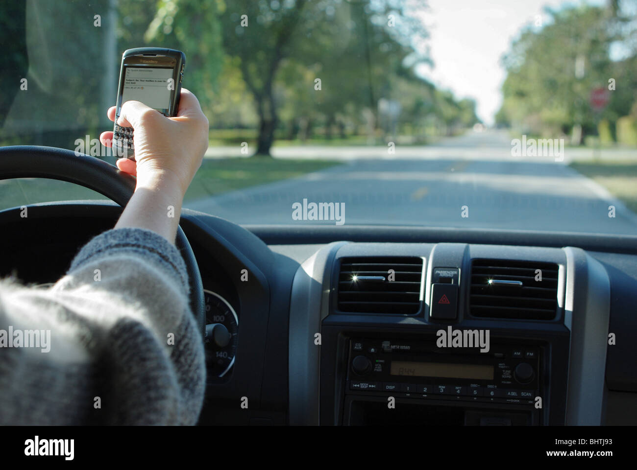 Woman is using PDA to check and type text messages while driving her