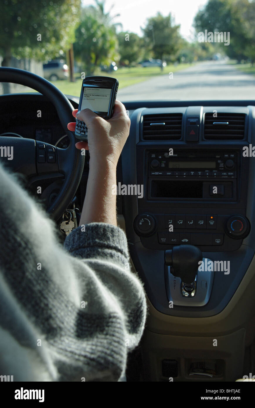 Woman is using PDA to check and type text messages while driving her