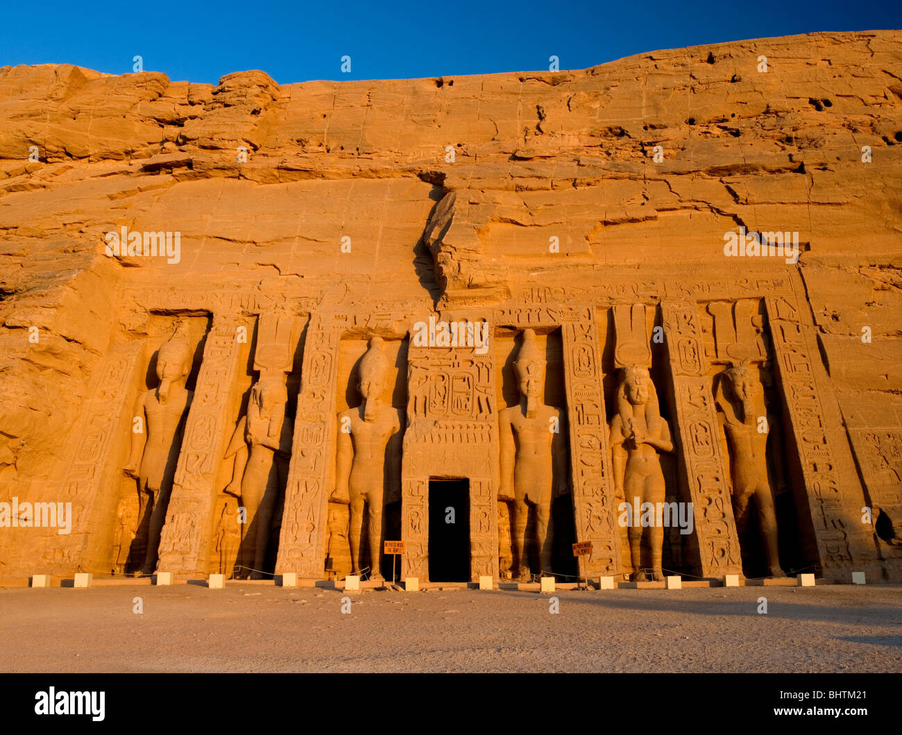 Carved statues Guarding the great temple of Hathor at sunrise, Abu Simbel, Egypt. Stock Photo