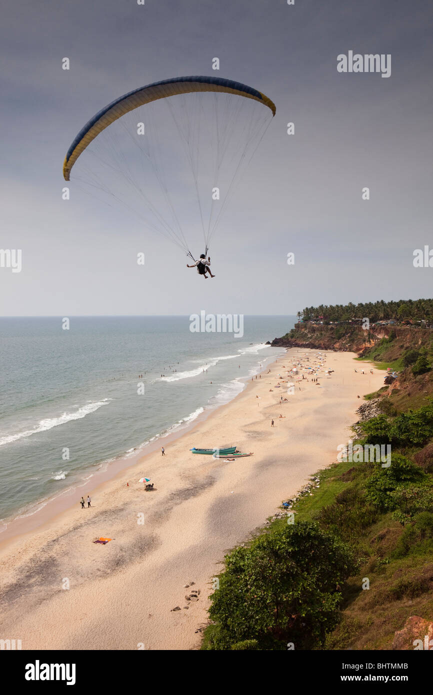 India, Kerala, Varkala beach, paraglider flying high above visitors Stock Photo