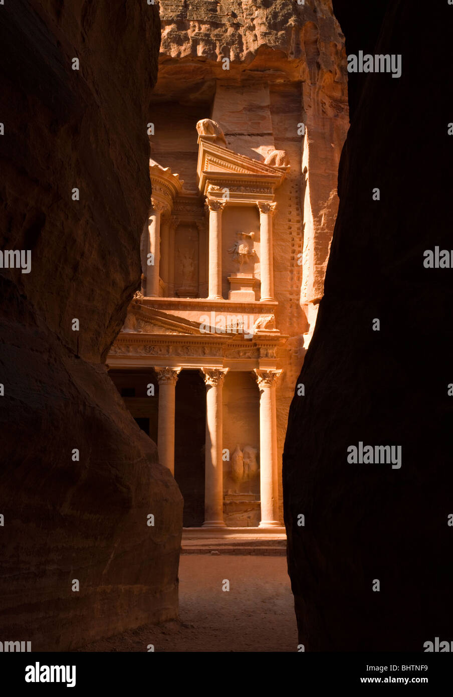 The Treasury or Al Khaznah at the ancient red rose city of Petra seen trough the Siq canyon in Wadi Musa, Jordan. Stock Photo