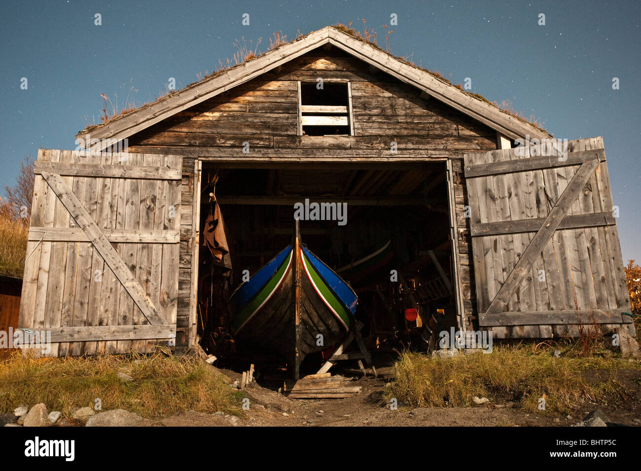 Open doors in this old boat house with a traditional norwegian boat