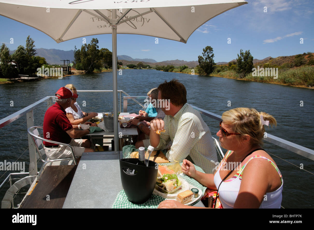 Tourists enjoying lunch aboard boat trip on the Breede River between