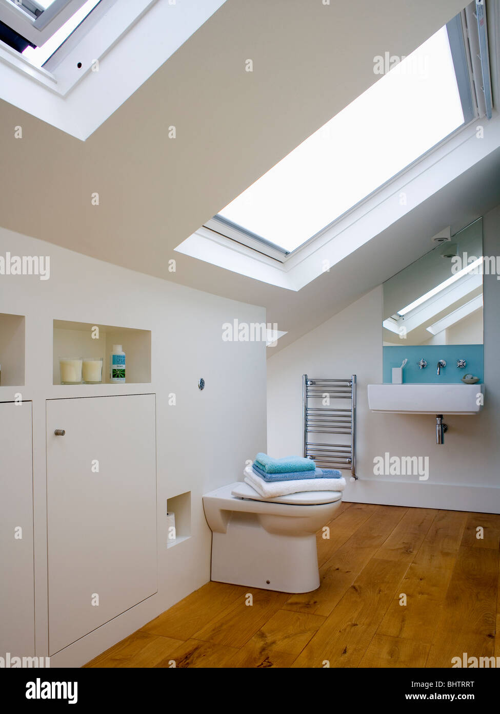 Velux windows in modern white loft conversion bathroom with wooden