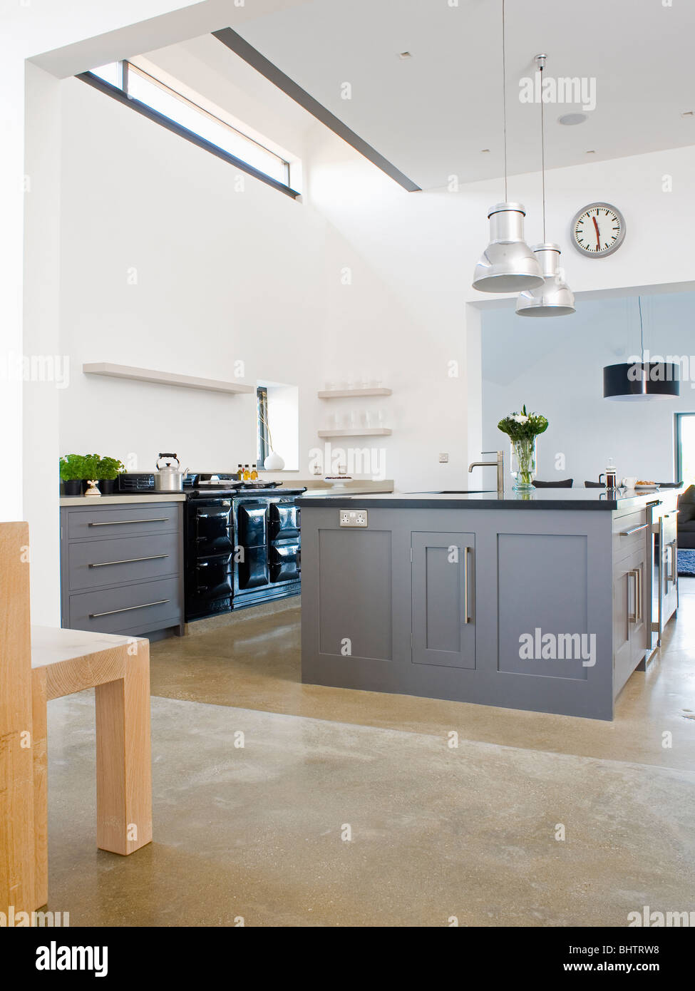 Grey fitted island unit in large modern white kitchen Stock Photo - Alamy
