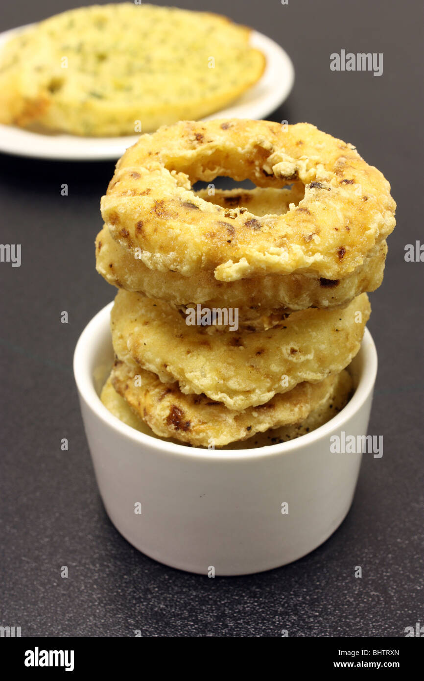 A side order of onion rings displayed in a small white ramekin dish Stock Photo