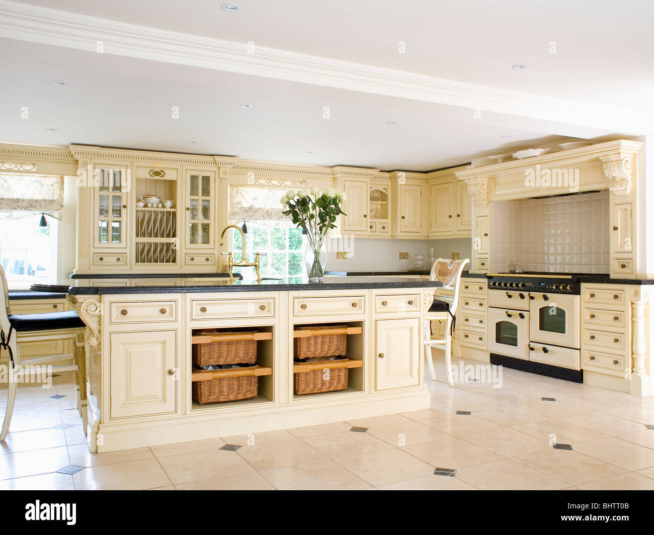 Storage baskets on shelves on island unit in large cream country kitchen  Stock Photo - Alamy