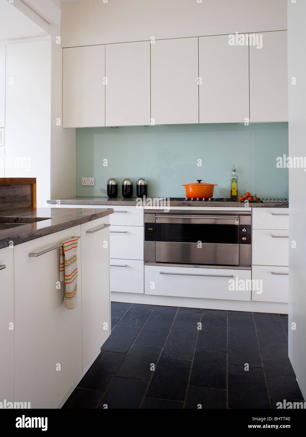 Black Floor Tiles In Modern White Kitchen With Glass Splash Back Stock Photo Alamy