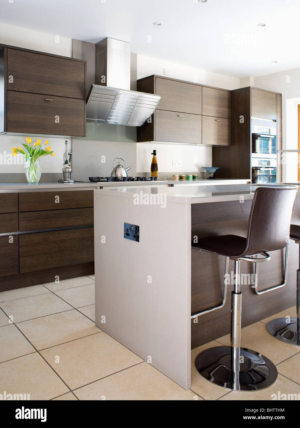 Black leather and chrome stools at breakfast bar on island unit in