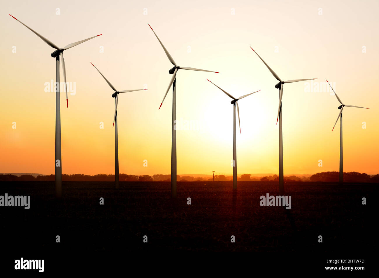 Turbines of a wind farm at sunset. Stock Photo