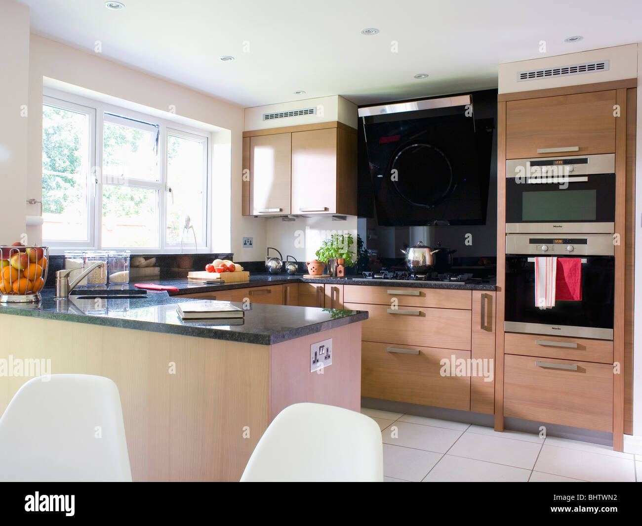 Eye level double oven in pale wood fitted unit in modern kitchen