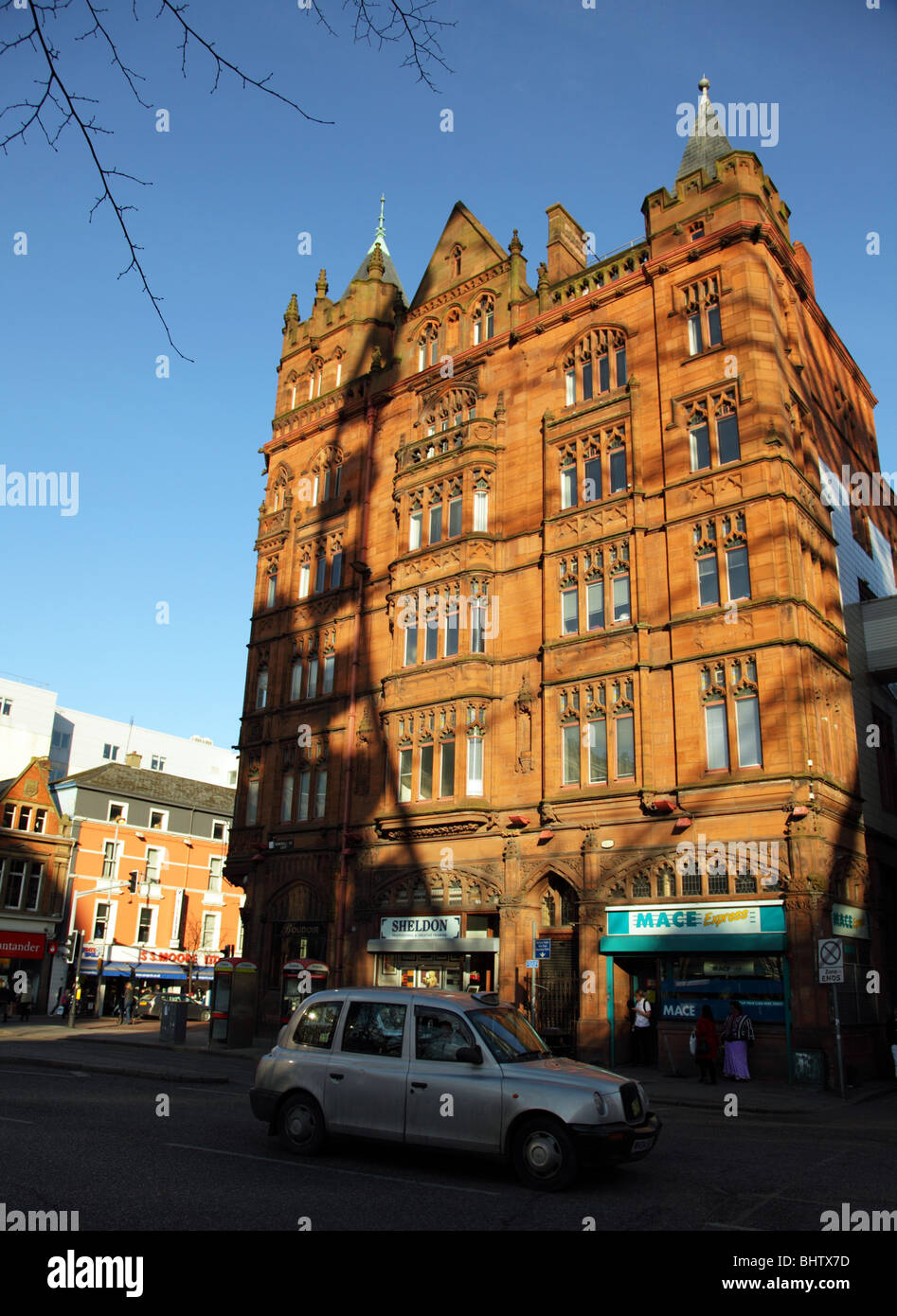Ocean Building, Donegall Square East, Belfast City Centre with a taxi driving by and a shadow of the Belfast Wheel been cast. Stock Photo