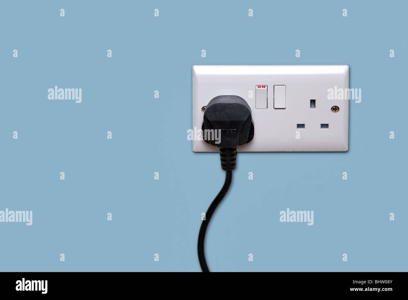 Double electrical power socket and single plug switched on, blue background. Stock Photo
