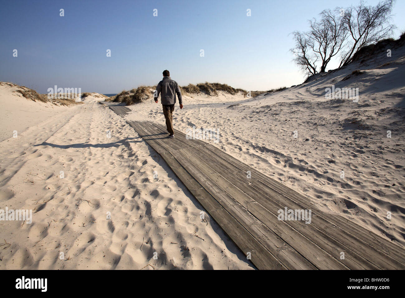 Man on a wooden walkway on a beach Stock Photo