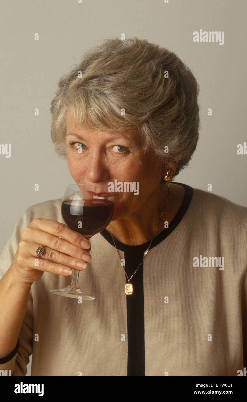 middle-aged woman drinking a glass of red wine Stock Photo - Alamy