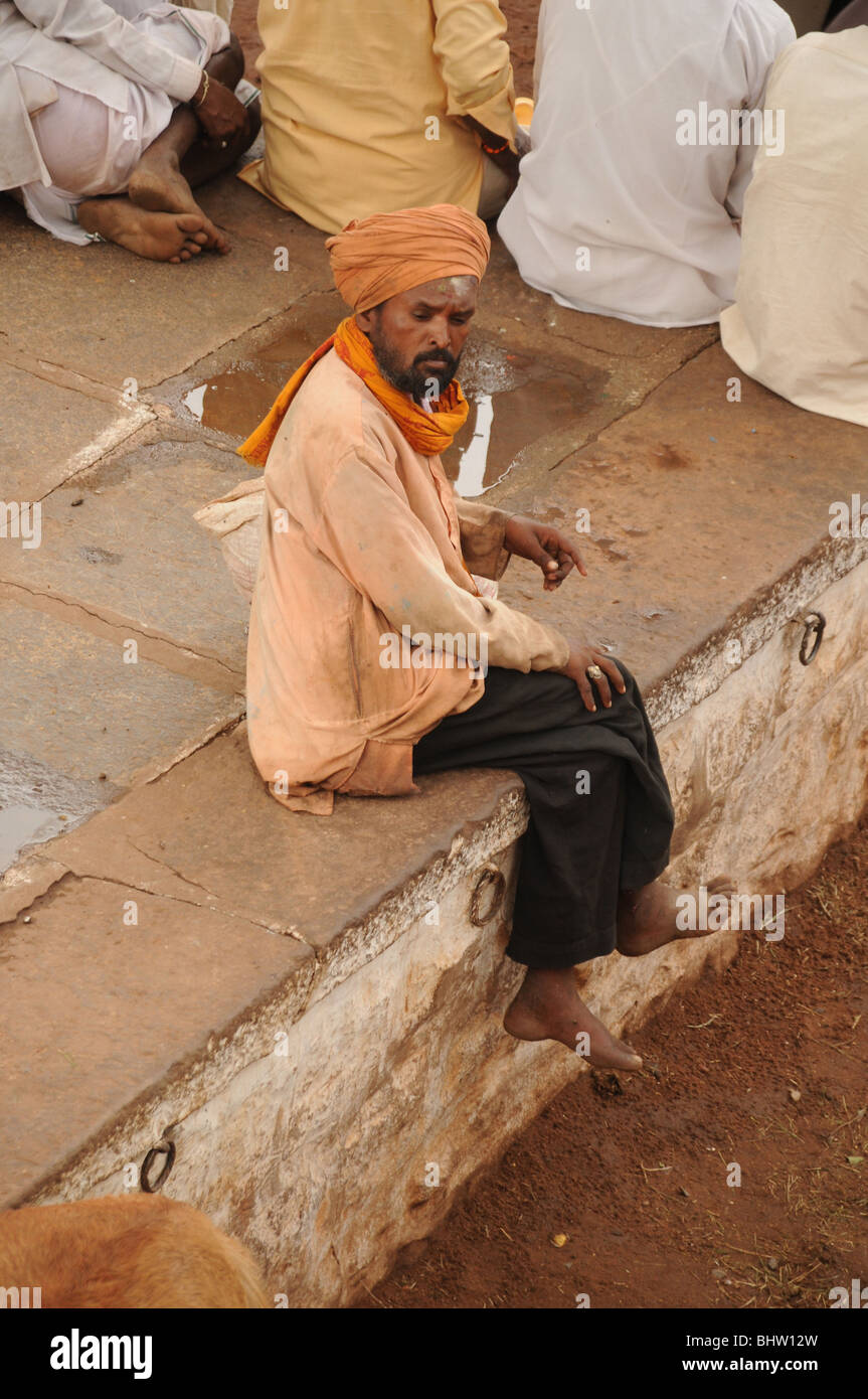 man with turban sits on wall Stock Photo
