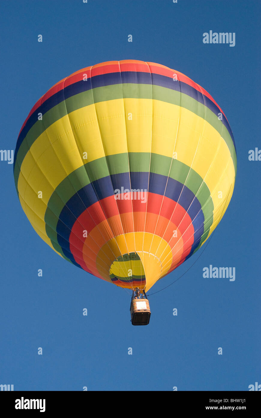 Hot air balloon flying up in a clear blue sky Stock Photo - Alamy