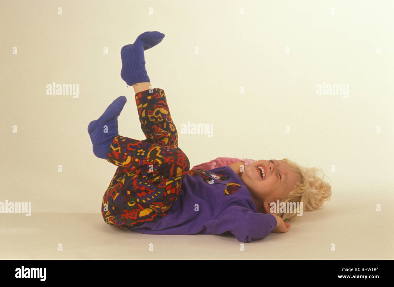 toddler lying on her back kicking her heels in the air and having a