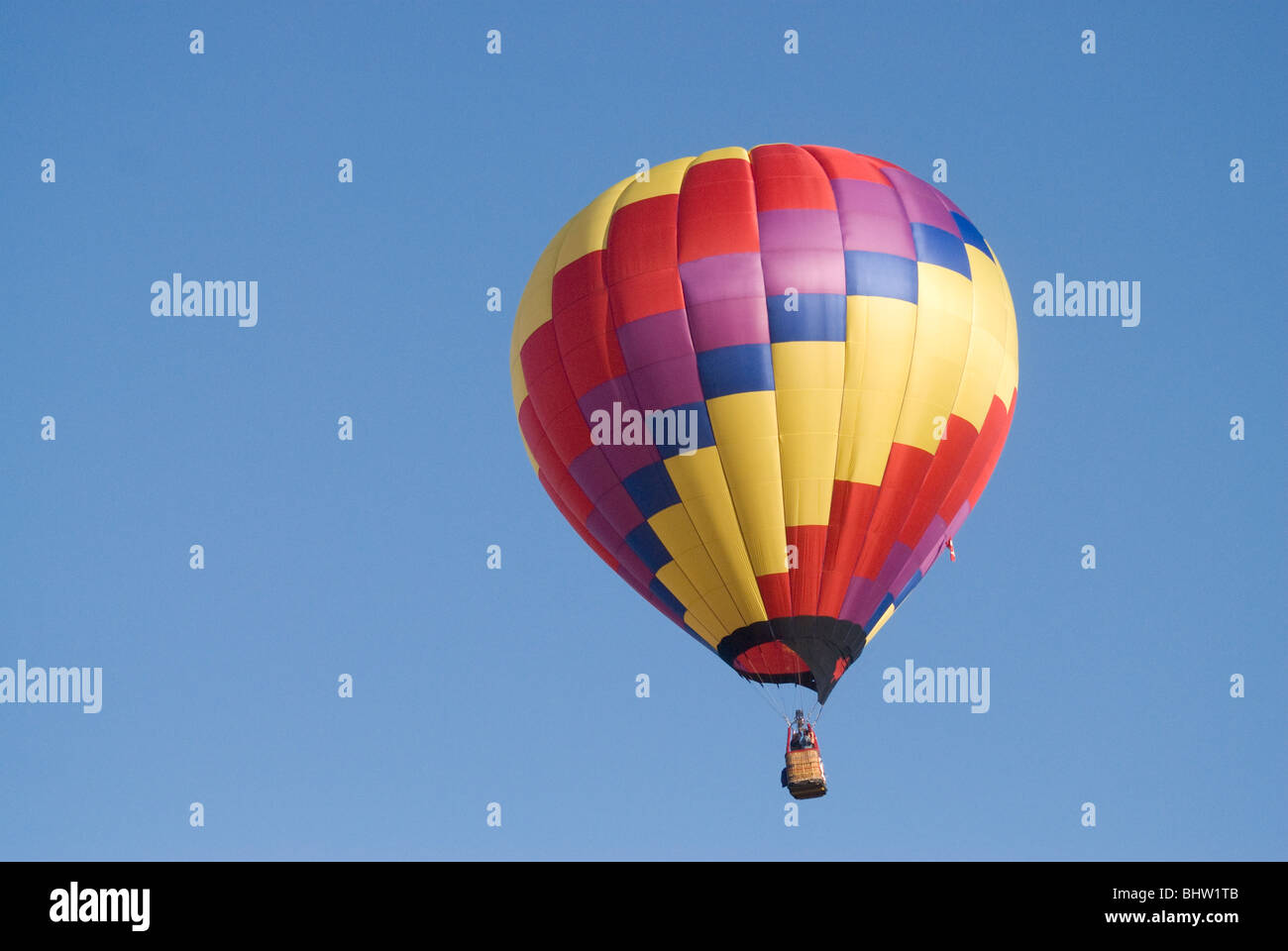 Big Hot air balloon flying up in a clear blue sky Stock Photo - Alamy