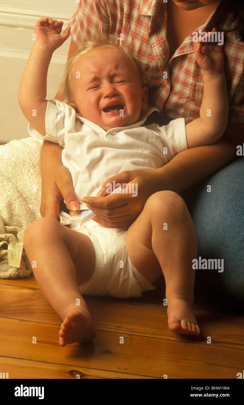 baby bawling as he is dressed Stock Photo