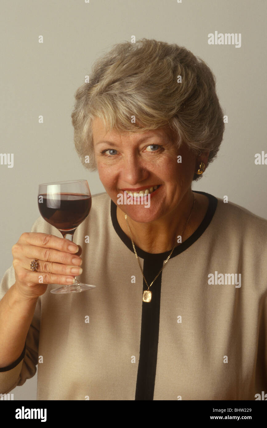 middle-aged woman drinking a glass of red wine Stock Photo - Alamy