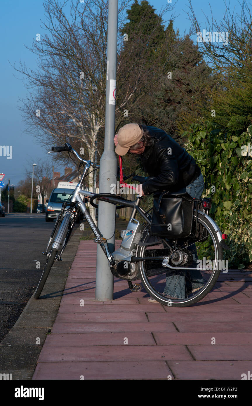 Bicycle thief takes wire cutters to steal chained up bike Stock Photo